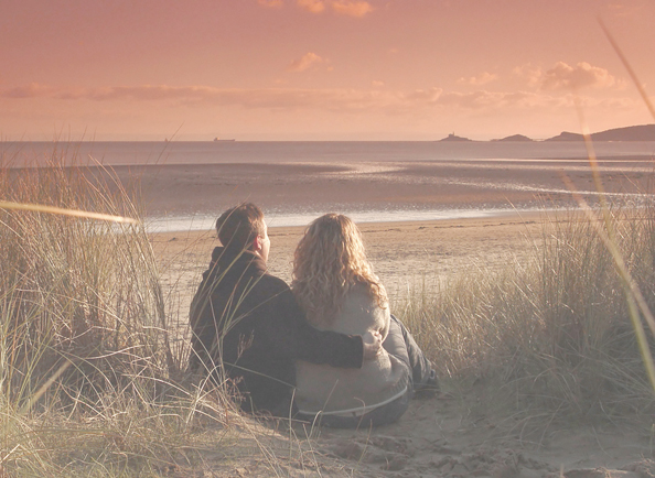A couple embracing on a beach at sunset